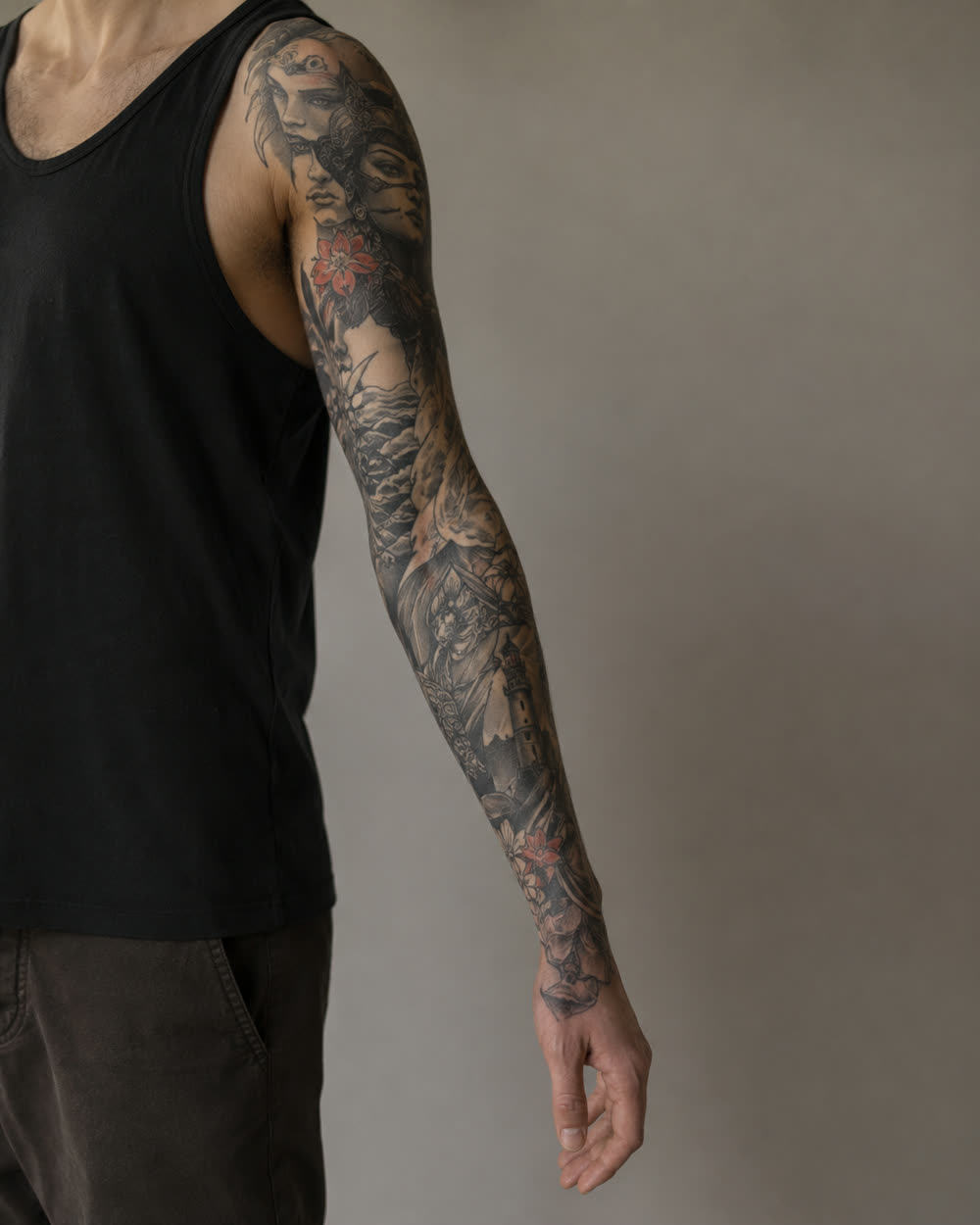 Illustrative full-sleeve tattoo with mixed motifs